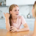 A teenage girl as she talks to her mom.